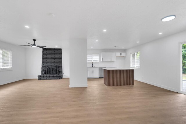 424 W Menlo Ave, Clovis, CA 93612 - unfurnished living room with recessed lighting, baseboards, light wood finished floors, and a fireplace
