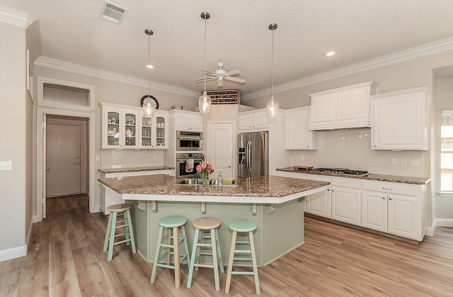 kitchen with stainless steel appliances, premium range hood, ceiling fan, white cabinetry, and ornamental molding