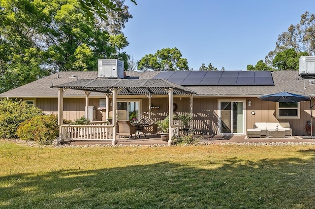 13801 E Rialto Ave, Sanger, CA 93657 - back of house featuring outdoor lounge area, a lawn, roof mounted solar panels, and a patio