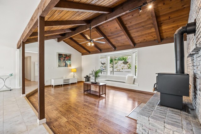 13801 E Rialto Ave, Sanger, CA 93657 - living area with wooden ceiling, a wood stove, ceiling fan, and baseboards