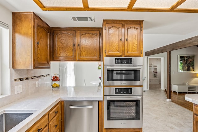 13801 E Rialto Ave, Sanger, CA 93657 - kitchen with appliances with stainless steel finishes, brown cabinets, decorative backsplash, and tile countertops