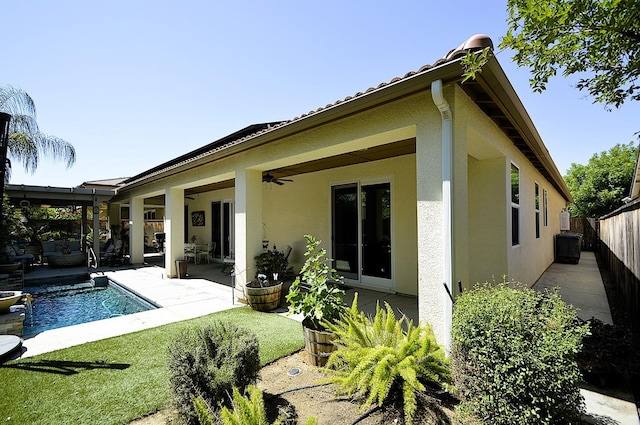rear view of property with stucco siding, a fenced backyard, ceiling fan, and a patio