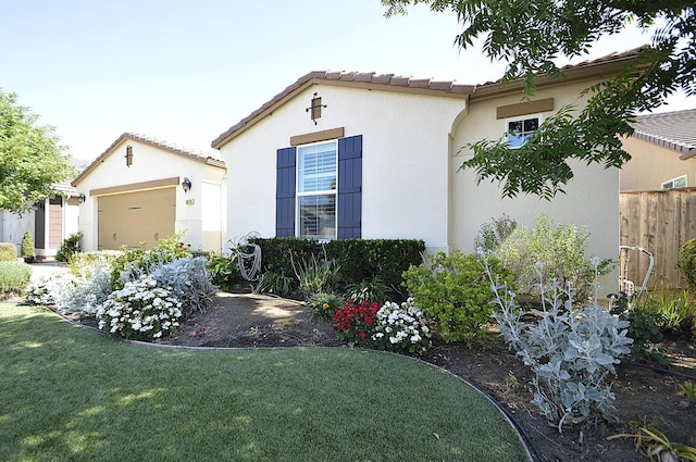 view of home's exterior with stucco siding, an attached garage, and a tiled roof
