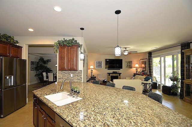 kitchen featuring black fridge, a sink, open floor plan, light tile patterned floors, and recessed lighting