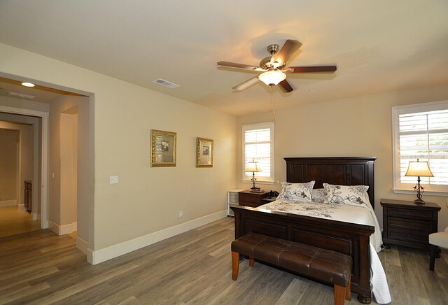 bedroom featuring wood finished floors, baseboards, and a ceiling fan