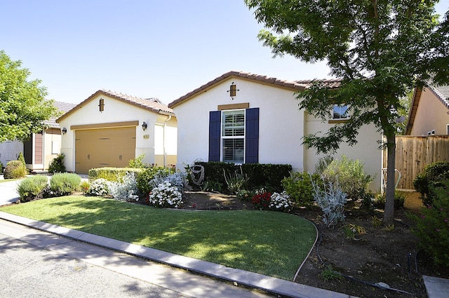 mediterranean / spanish home featuring stucco siding, a tile roof, a garage, and concrete driveway