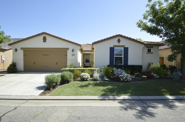 view of front of house with stucco siding, a tiled roof, an attached garage, concrete driveway, and a front lawn