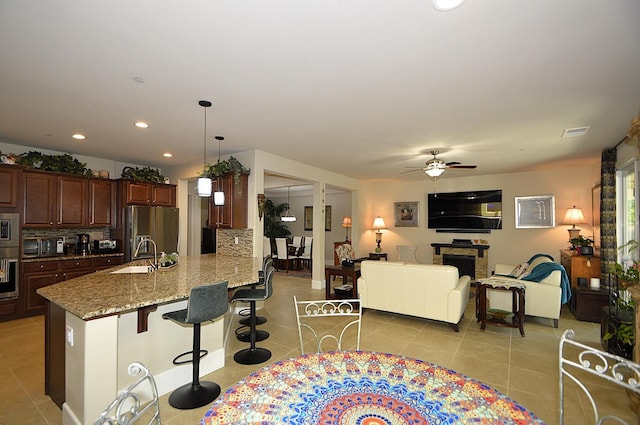 3476 Trenton Ln, Clovis, CA 93619 - kitchen with appliances with stainless steel finishes, a ceiling fan, tasteful backsplash, a breakfast bar area, and recessed lighting