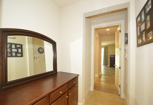 hallway featuring light tile patterned floors and baseboards