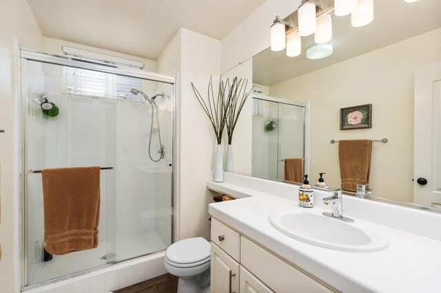 full bath with a shower stall, toilet, and vanity