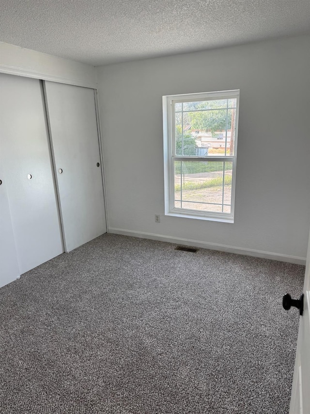 28640 Ward St, Madera, CA 93638 - unfurnished bedroom featuring carpet floors, a closet, and a textured ceiling