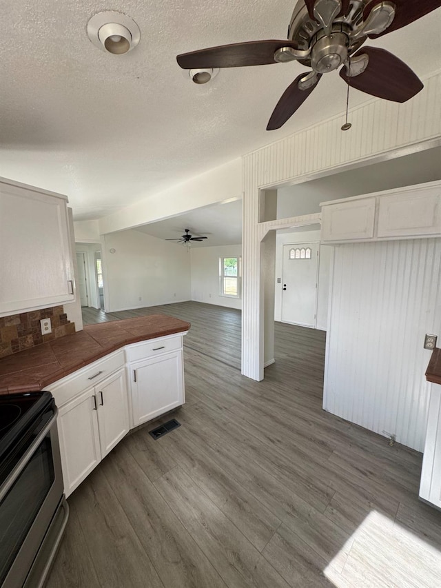 28640 Ward St, Madera, CA 93638 - kitchen featuring a ceiling fan, white cabinets, dark wood-style flooring, open floor plan, and stainless steel electric range