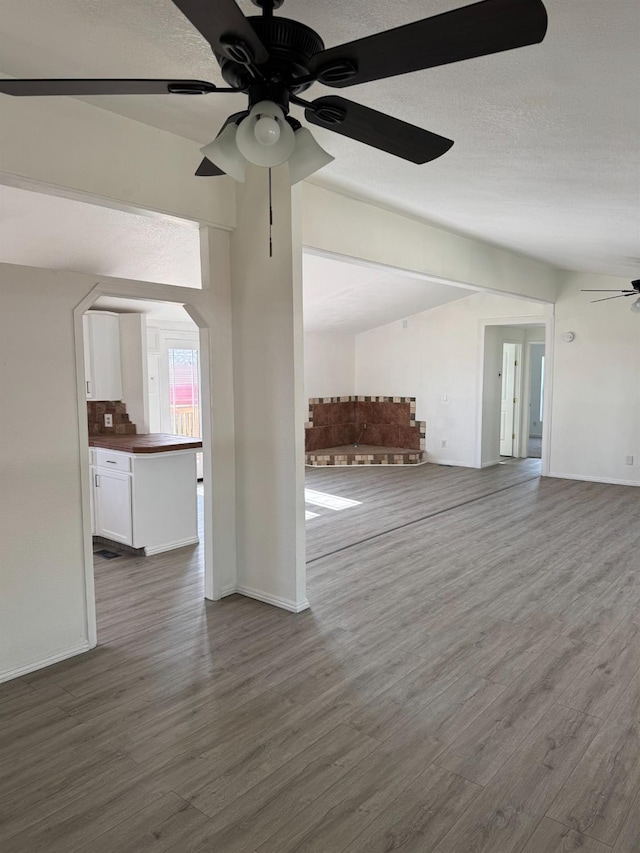 28640 Ward St, Madera, CA 93638 - unfurnished living room with ceiling fan, dark wood-style floors, baseboards, and a textured ceiling