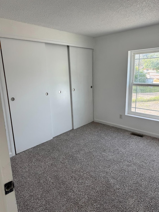 28640 Ward St, Madera, CA 93638 - unfurnished bedroom featuring carpet, a closet, and a textured ceiling