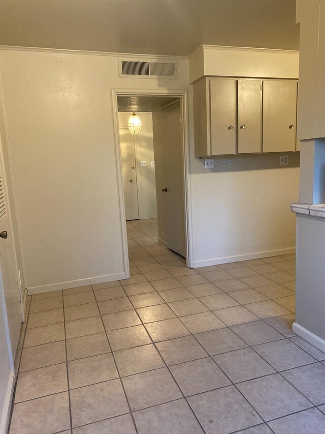 unfurnished room featuring light tile patterned flooring and baseboards