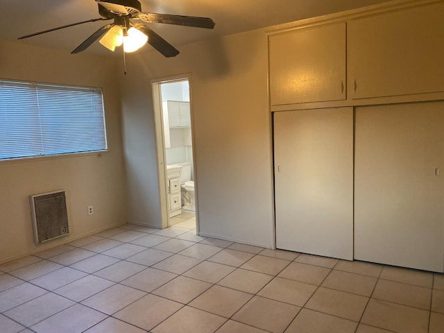 unfurnished bedroom with multiple windows, light tile patterned floors, a ceiling fan, and a closet