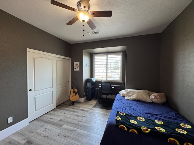 1822 N Magnolia, Clovis, CA 93619 - bedroom with light wood-style flooring, a ceiling fan, baseboards, a textured ceiling, and a textured wall