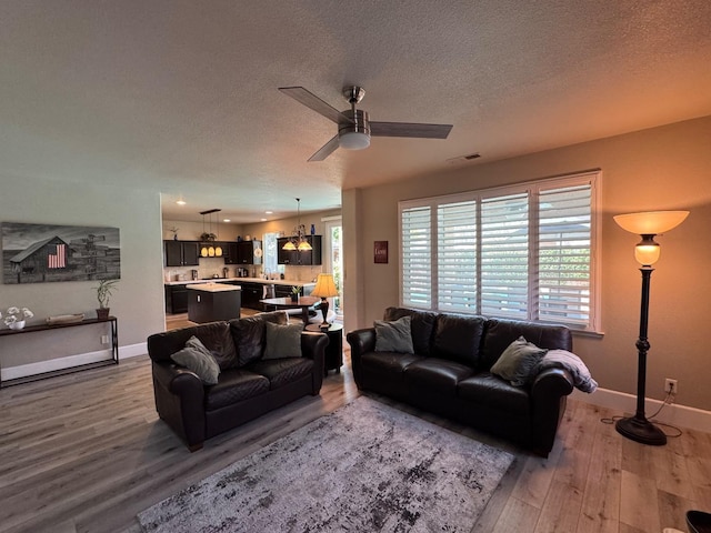 1822 N Magnolia, Clovis, CA 93619 - living area with wood finished floors, a textured ceiling, baseboards, and a ceiling fan