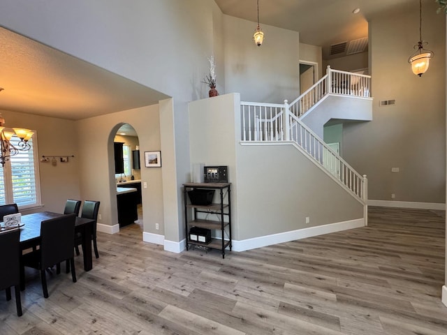 1822 N Magnolia, Clovis, CA 93619 - dining room with wood finished floors, arched walkways, a high ceiling, stairs, and a chandelier