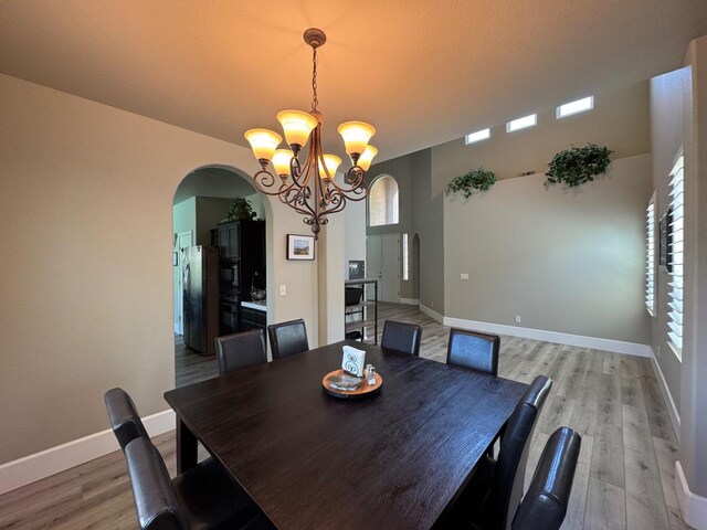 1822 N Magnolia, Clovis, CA 93619 - dining space with arched walkways, a chandelier, healthy amount of natural light, and light wood finished floors