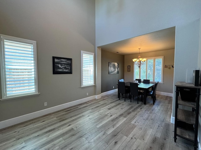 1822 N Magnolia, Clovis, CA 93619 - dining area featuring a chandelier, light wood finished floors, baseboards, and a towering ceiling