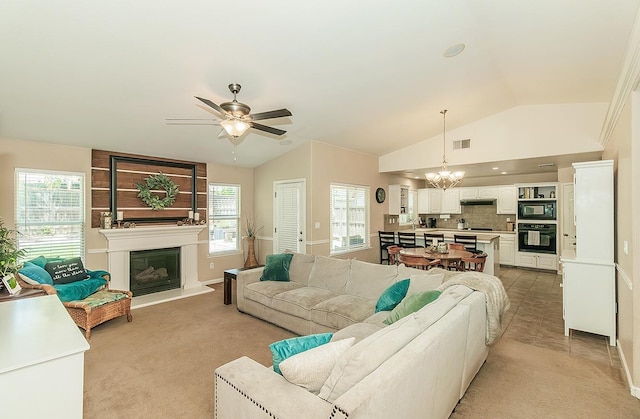 6588 E Lowe Ave, Fresno, CA 93727 - living room with a chandelier, lofted ceiling, ceiling fan, a large fireplace, and light colored carpet