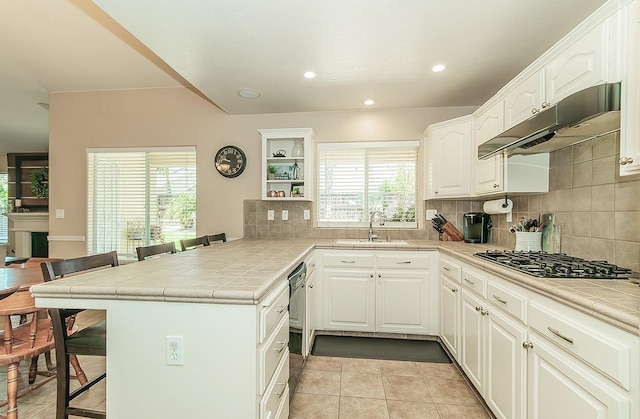 6588 E Lowe Ave, Fresno, CA 93727 - kitchen featuring under cabinet range hood, a kitchen breakfast bar, a sink, a peninsula, and gas stovetop