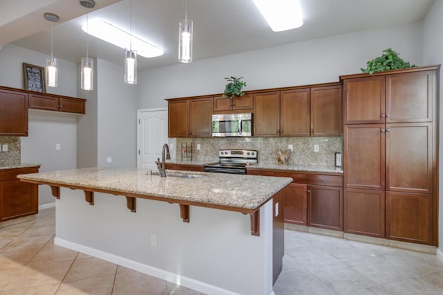 kitchen with appliances with stainless steel finishes, a sink, tasteful backsplash, and light tile patterned flooring