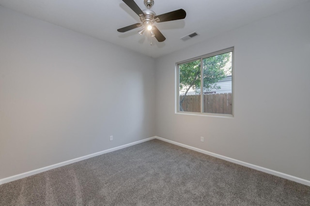 carpeted spare room with baseboards and a ceiling fan