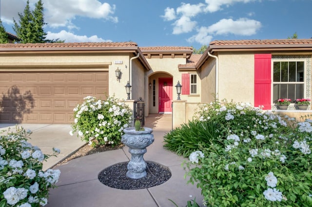 mediterranean / spanish-style home with stucco siding, a garage, and driveway