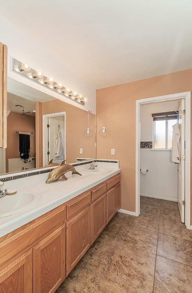 3042 Love St, Selma, CA 93662 - bathroom featuring double vanity, tile patterned flooring, and baseboards