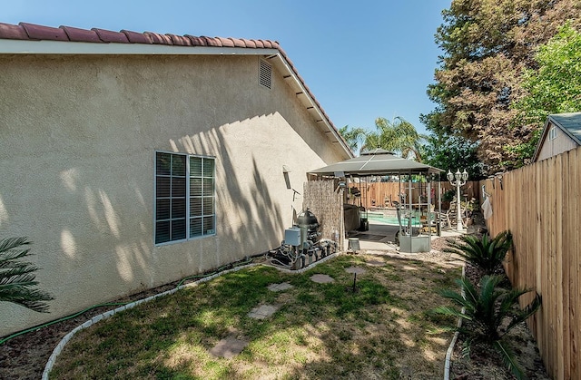 3042 Love St, Selma, CA 93662 - view of home's exterior featuring a gazebo, stucco siding, and a fenced backyard