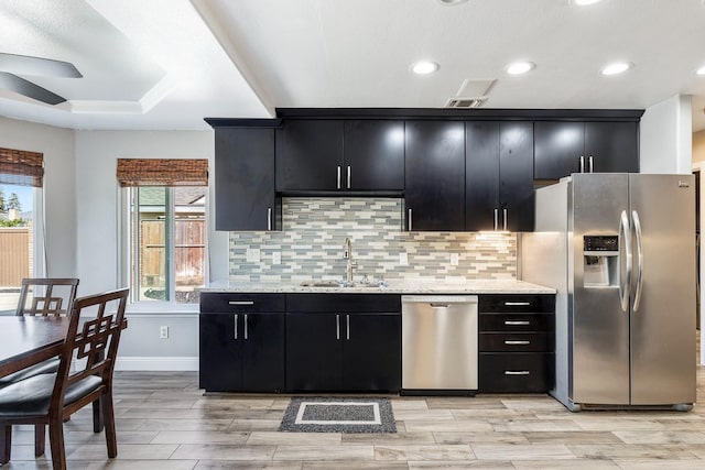 2371 Sophia Ln, Kingsburg, CA 93631 - kitchen featuring stainless steel appliances, a sink, dark cabinetry, backsplash, and recessed lighting