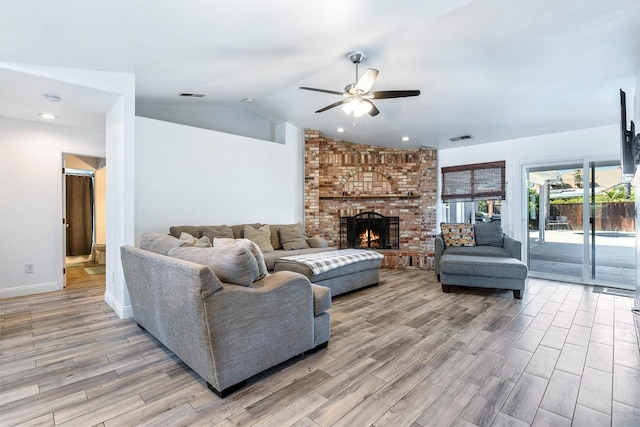 2371 Sophia Ln, Kingsburg, CA 93631 - living area featuring light wood-type flooring, a ceiling fan, vaulted ceiling, a brick fireplace, and baseboards