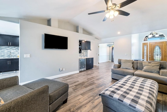 2371 Sophia Ln, Kingsburg, CA 93631 - living area with beverage cooler, lofted ceiling, light wood finished floors, ceiling fan, and baseboards