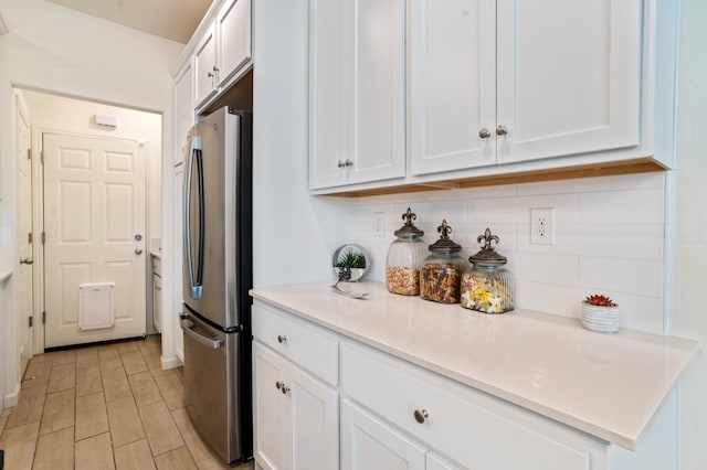 6458 E Riesling Dr, Fresno, CA 93727 - kitchen with freestanding refrigerator, tasteful backsplash, white cabinets, and light countertops