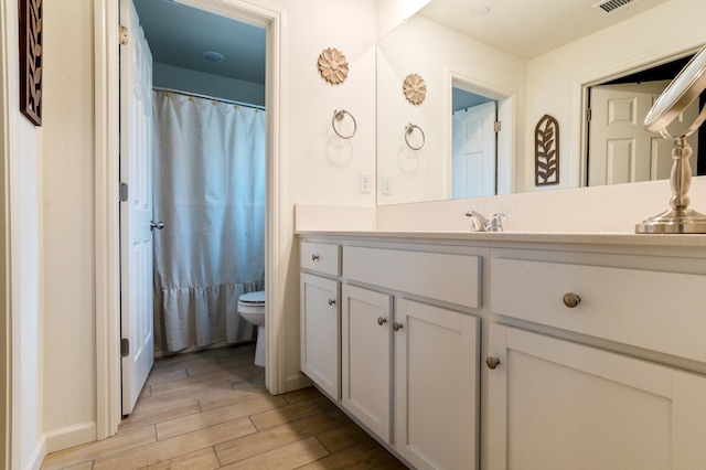 6458 E Riesling Dr, Fresno, CA 93727 - bathroom with toilet, wood finished floors, vanity, and baseboards