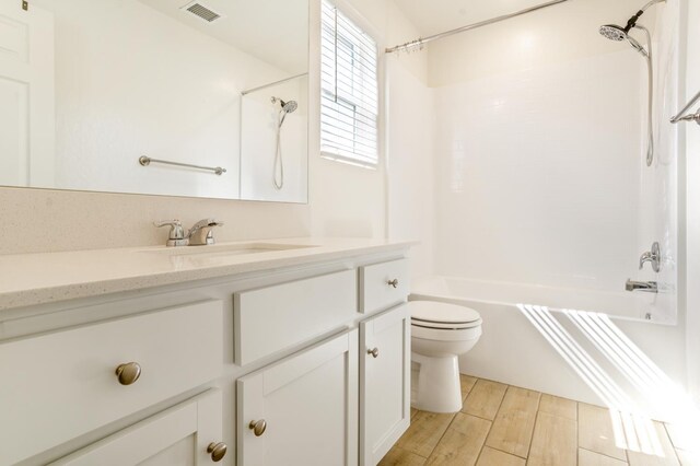 6458 E Riesling Dr, Fresno, CA 93727 - bathroom featuring toilet, vanity, wood finished floors, and  shower combination