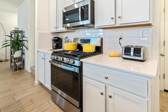 6458 E Riesling Dr, Fresno, CA 93727 - kitchen featuring stainless steel appliances, backsplash, white cabinets, and light countertops
