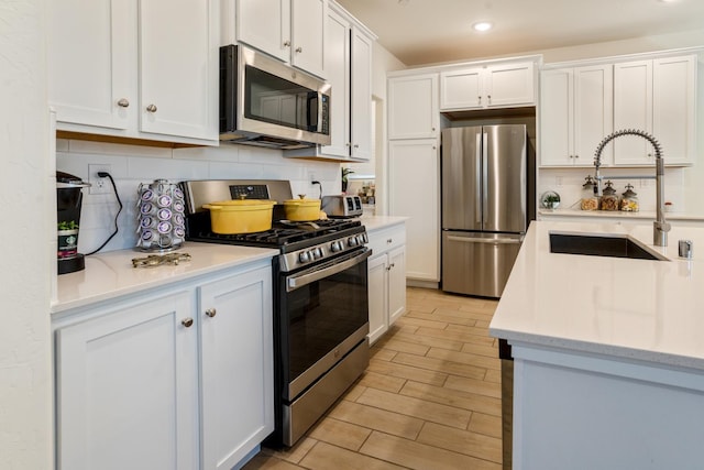 6458 E Riesling Dr, Fresno, CA 93727 - kitchen featuring stainless steel appliances, a sink, decorative backsplash, white cabinetry, and recessed lighting