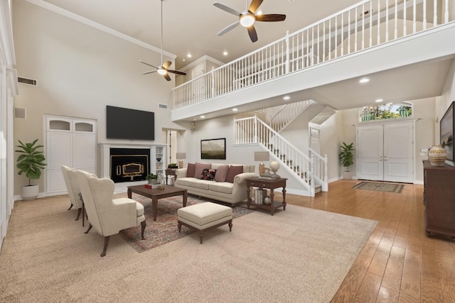 2758 N Highland Ave, Fresno, CA 93737 - living room featuring a ceiling fan, a towering ceiling, stairway, a fireplace, and ornamental molding