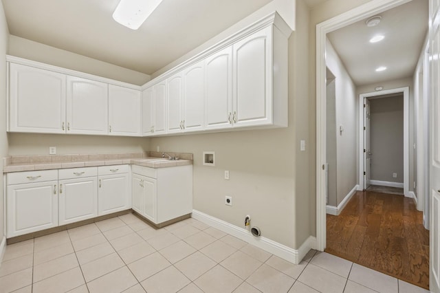 2758 N Highland Ave, Fresno, CA 93737 - washroom with washer hookup, hookup for an electric dryer, baseboards, light tile patterned floors, and cabinet space