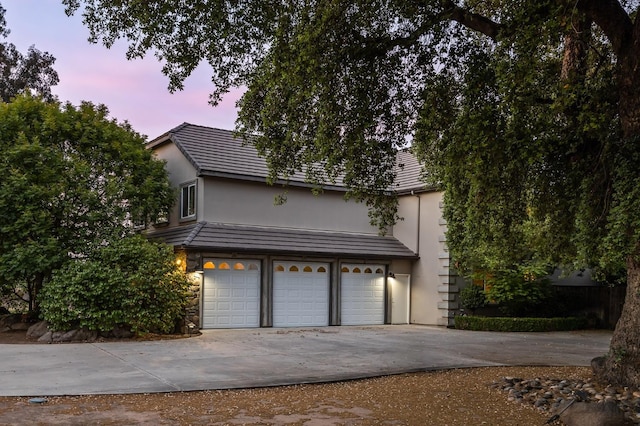 2758 N Highland Ave, Fresno, CA 93737 - view of front facade featuring driveway, a garage, stucco siding, and a tile roof