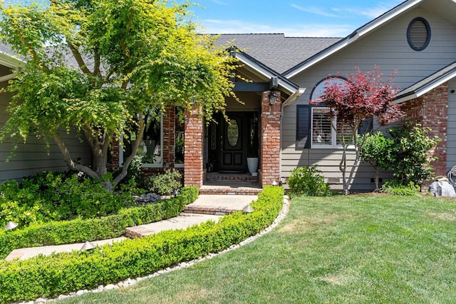 1517 W Fir Ave, Fresno, CA 93711 - view of exterior entry featuring brick siding, a yard, and a shingled roof