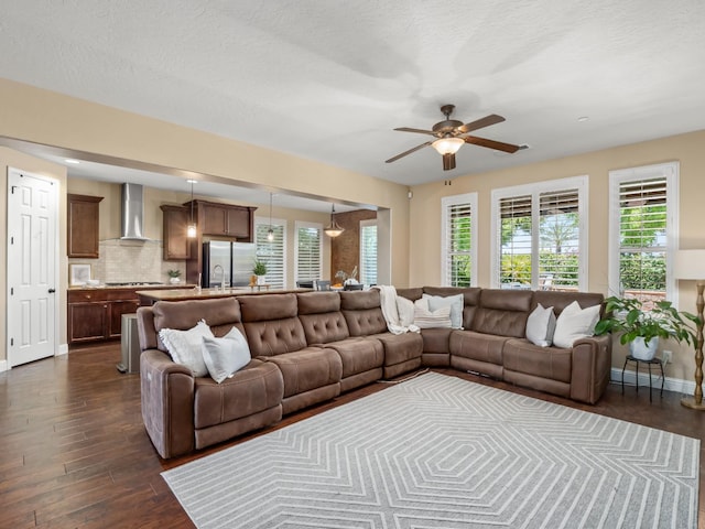 living room with dark wood-type flooring, ceiling fan, and baseboards