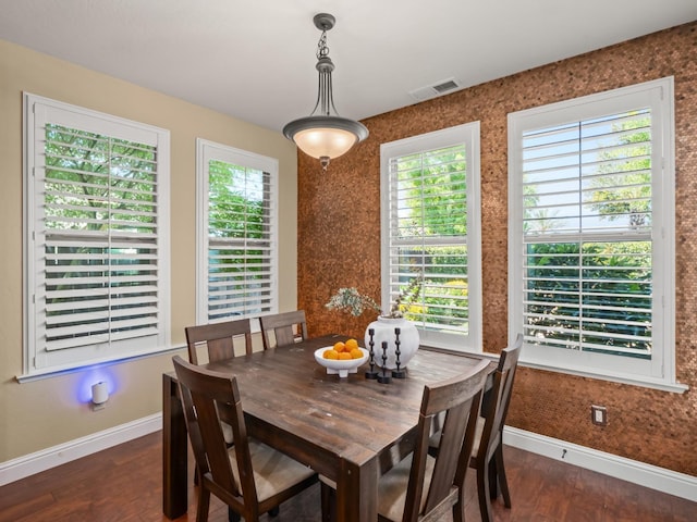 dining area with baseboards, plenty of natural light, and dark wood-style floors