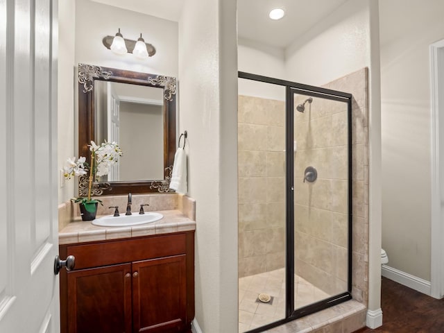full bath featuring a shower stall, vanity, and toilet
