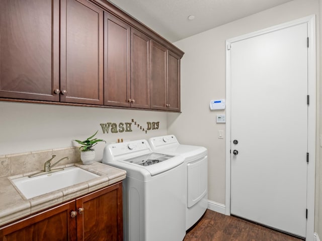 laundry area featuring cabinet space, washing machine and clothes dryer, dark wood finished floors, and baseboards