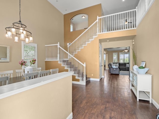 foyer entrance featuring a high ceiling, ceiling fan, stairs, hardwood / wood-style floors, and baseboards
