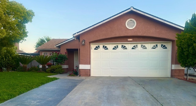 13711 E Amigo Dr, Parlier, CA 93648 - view of front facade featuring a garage, concrete driveway, stucco siding, and a front yard